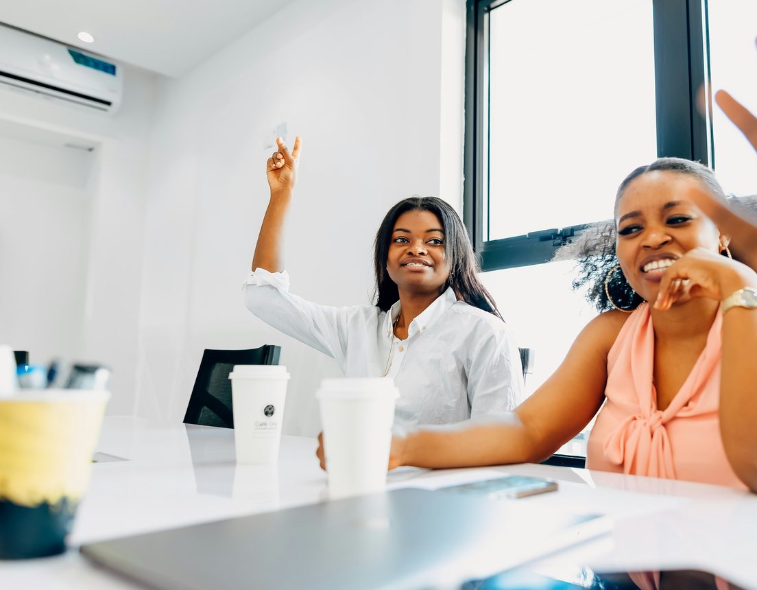 Two colleagues smiling around a meeting table